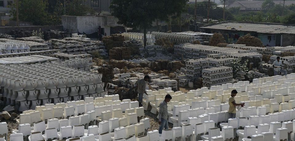 Indian workers check newly built toilets in the stockyard of a factory in Morbi