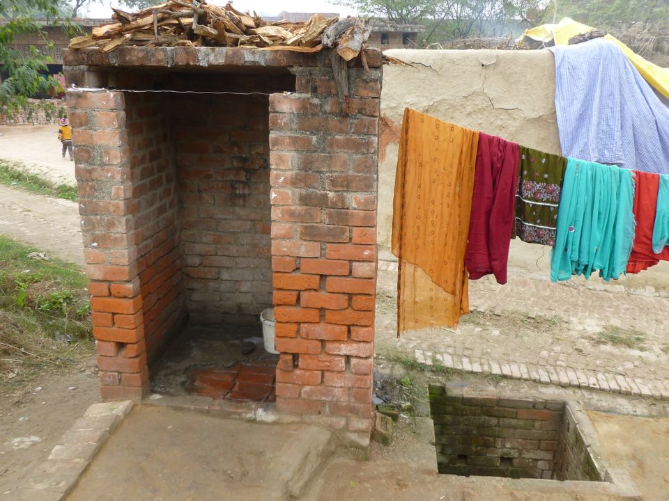 An IAY latrine in which both the pit and the superstructure were constructed.  Cement has been poured in the pan, and the superstructure is used to wash clothes.